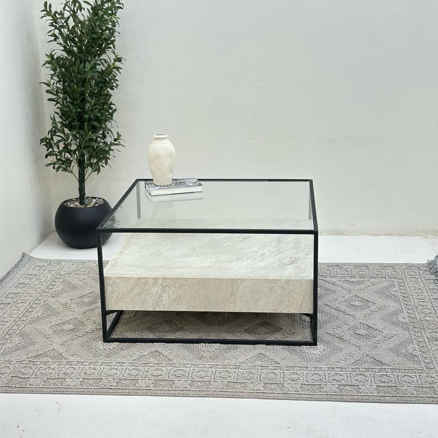 Coffee table with a transparent glass surface, half replaced with stone, iron base.