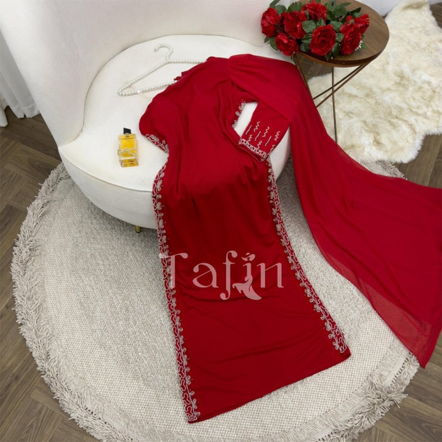 A tight dress at the waist and long sleeve on one shoulder embroidered on the sides
