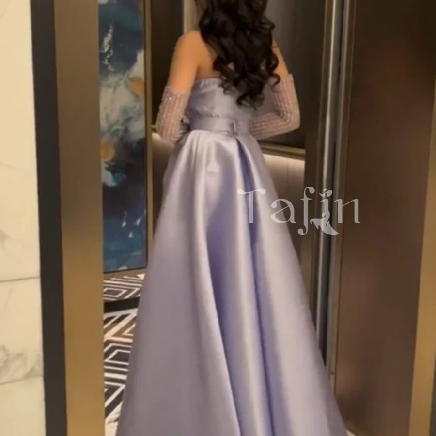 A dress with very luxurious fabric, satin, tight at the waist, with embroidered cuffs