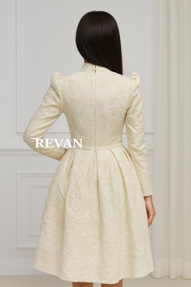 A luxurious midi dress from Rivan in an off-white color with embroidery.