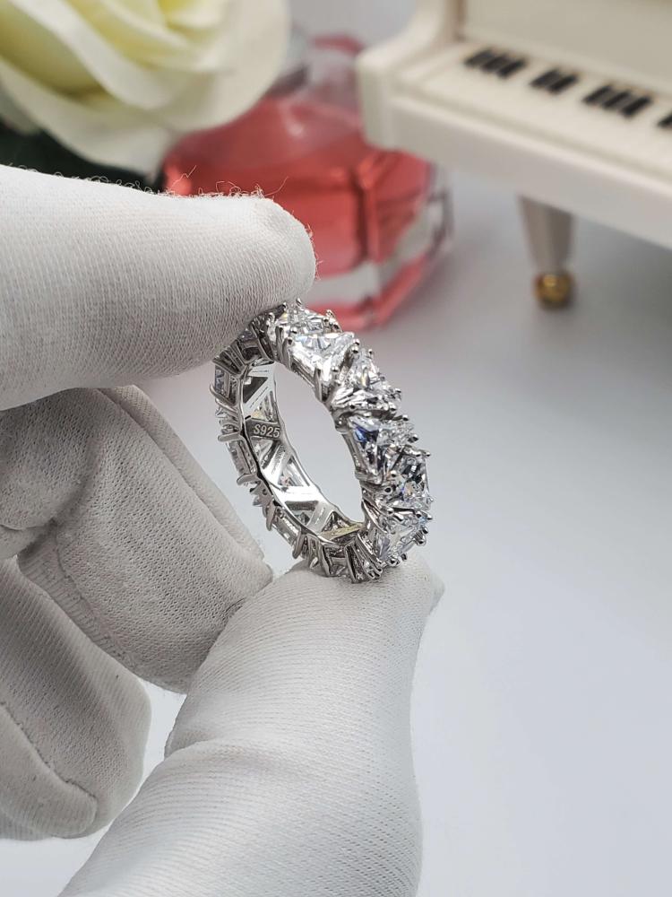 A silver ring set with a row of zircon triangles