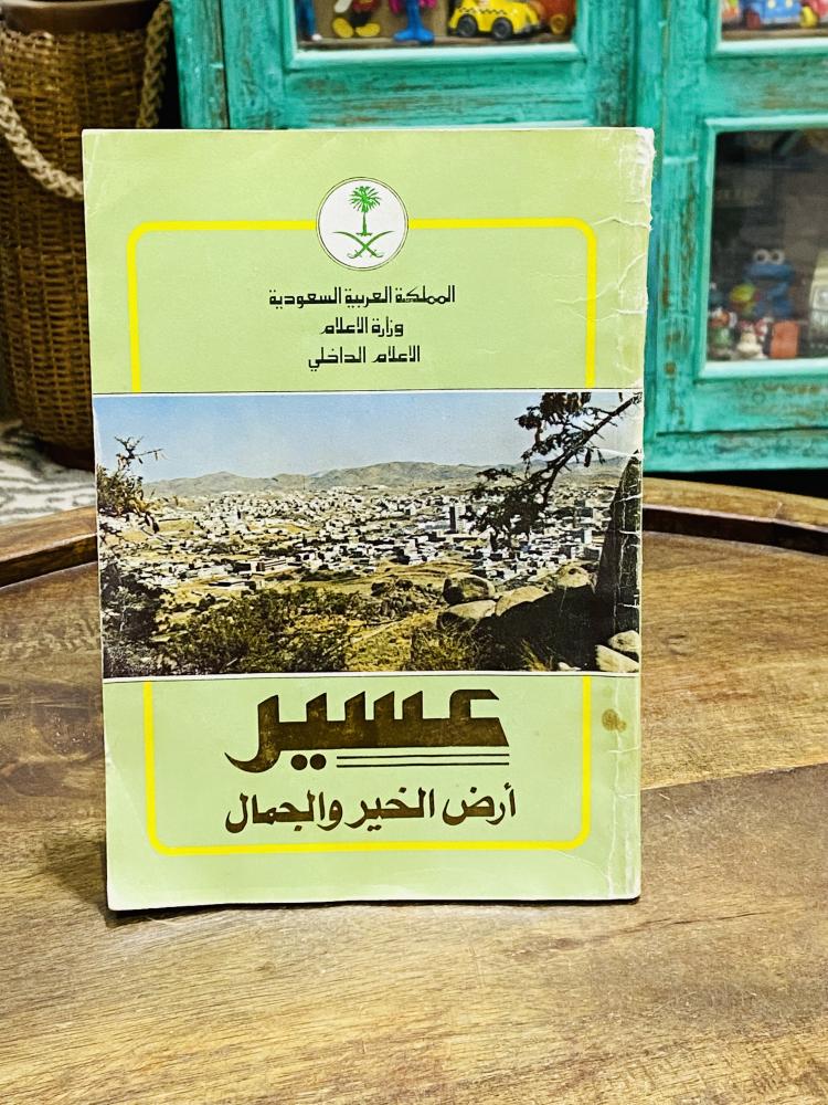A beautiful and old book titled Asir Land of Goodness and Beauty; issued by the Ministry of Information; contains many pictures of the Asir region; the book is slightly affected by humidity.