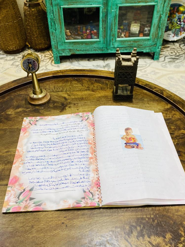 من النوادر؛ كراسة أو دفتر لإحدى الطالبات بعنوان رعلية الطفل مليء بالمعلومات والصور الملصقة