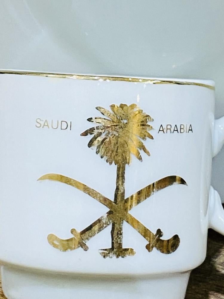 One of the very rare items; a 5 cm tall coffee cup made of pure porcelain with the country's emblem of two swords and a palm tree in gold color on the cup and saucer; expertly made, Japan craftsmanship (made specifically for one of the palaces) considered