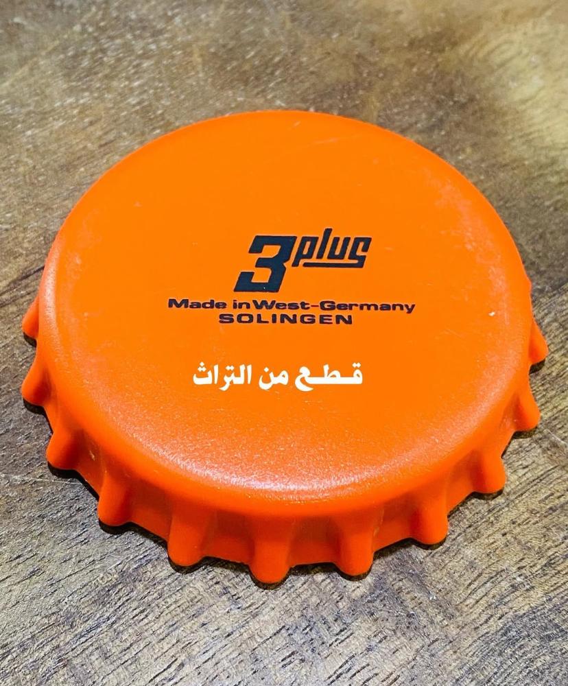 من البنود الشحيحة؛ مفك أو فتاحة غراش مرطبات على شكل غطاء المشروبات الغازية كبير الحجم؛ قديم جداً بلون مميز وأنيق وملفت؛ مكمل لركن البقالة في المتحف؛ صناعة ألمانيا الغربية