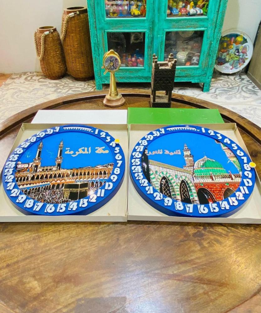 من النوادر؛ تعليقة جدارية بتقويم يدوي بالأشهر والأيام يتم تغيير الأيام بالدبوس الأصفر الواضح في الصور وبداخل التقويم صورة للحرم المكي والحرم المدني بلونين للإطار البني والأزرق؛ قديمة ومخزنة بالكرتون تخزين ممتاز؛ صناعة اليابان