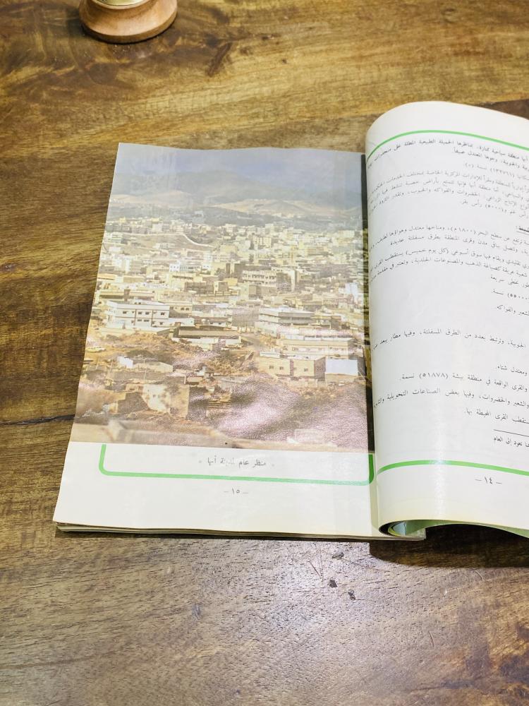 A beautiful and old book titled Asir Land of Goodness and Beauty; issued by the Ministry of Information; contains many pictures of the Asir region; the book is slightly affected by humidity.