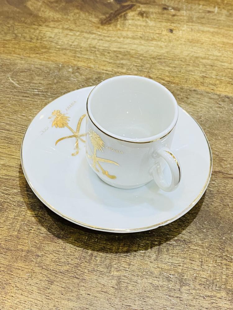 One of the very rare items; a 5 cm tall coffee cup made of pure porcelain with the country's emblem of two swords and a palm tree in gold color on the cup and saucer; expertly made, Japan craftsmanship (made specifically for one of the palaces) considered