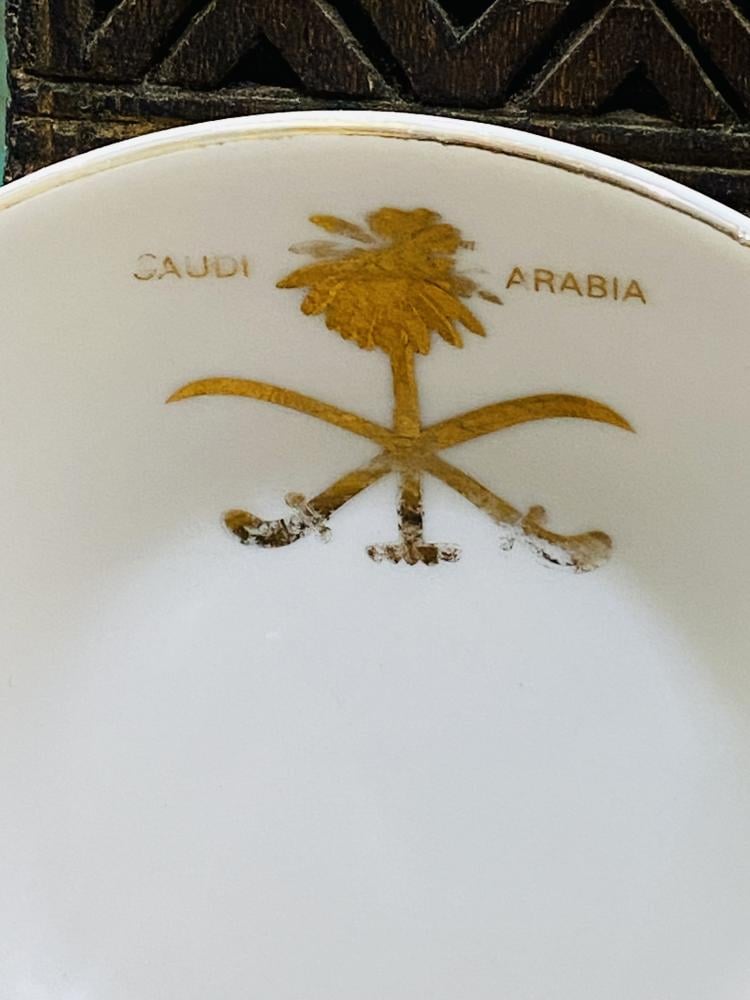 One of the very rare items; a 5 cm tall coffee cup made of pure porcelain with the country's emblem of two swords and a palm tree in gold color on the cup and saucer; expertly made, Japan craftsmanship (made specifically for one of the palaces) considered
