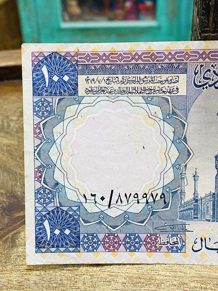 عملة الملك خالد فئة ١٠٠ ريال حالة عالية جداً (يوجد قطع في الزاوية اليمنى السفلية)