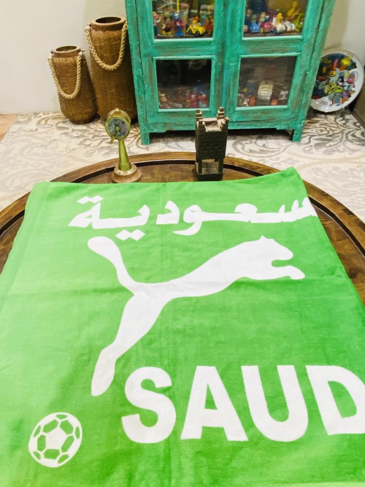 من البنود المميزة؛ منشفة بطول ١٢٠سم بشعار المنتخب السعودي؛ مخزنة بالمغلف الخاص بها
