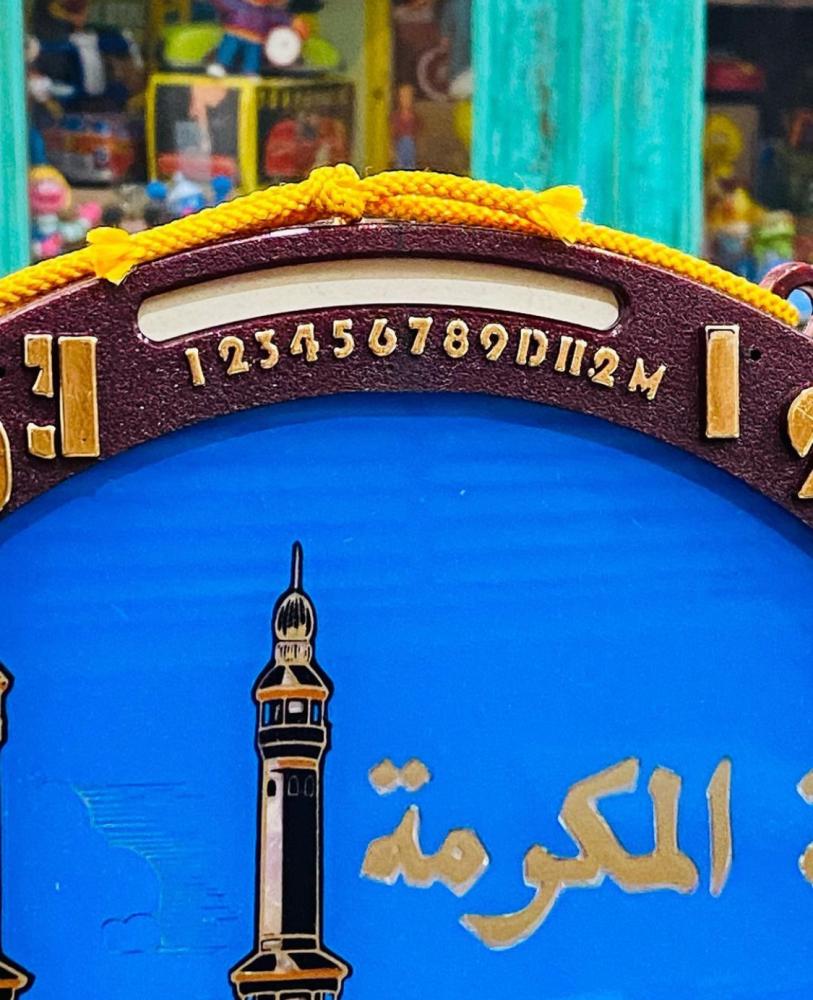 من النوادر؛ تعليقة جدارية بتقويم يدوي بالأشهر والأيام يتم تغيير الأيام بالدبوس الأصفر الواضح في الصور وبداخل التقويم صورة للحرم المكي والحرم المدني بلونين للإطار البني والأزرق؛ قديمة ومخزنة بالكرتون تخزين ممتاز؛ صناعة اليابان