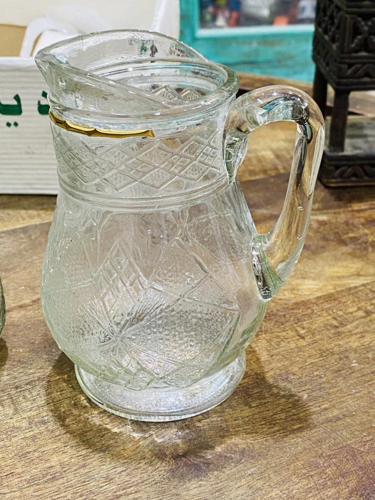 طقم ديكوري من الزجاج المتين جداً بمقاس صغير عبارة عن جيك بإرتفاع ١٥ سم تقريباً وعدد ٦ كاسات بحجم بيالة الشاهي تقريباً؛ قديم ومخزن بالكرتون لم يستخدم