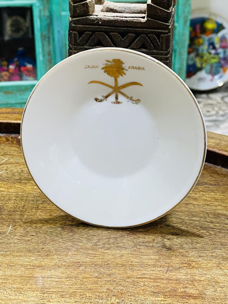 One of the very rare items; a 5 cm tall coffee cup made of pure porcelain with the country's emblem of two swords and a palm tree in gold color on the cup and saucer; expertly made, Japan craftsmanship (made specifically for one of the palaces) considered