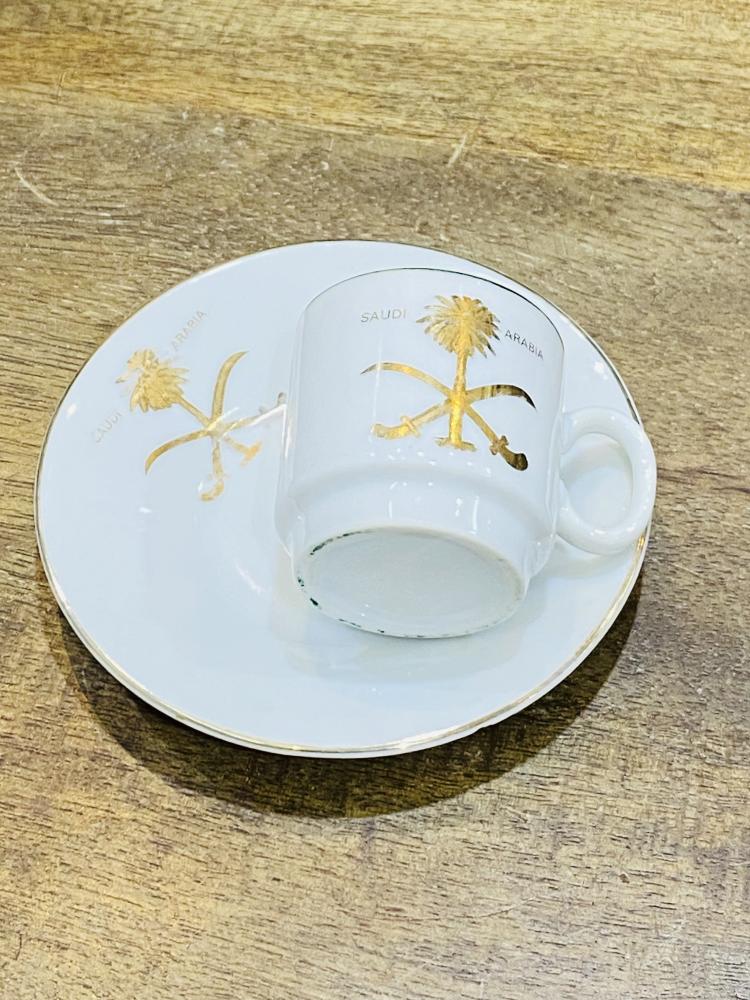 One of the very rare items; a 5 cm tall coffee cup made of pure porcelain with the country's emblem of two swords and a palm tree in gold color on the cup and saucer; expertly made, Japan craftsmanship (made specifically for one of the palaces) considered
