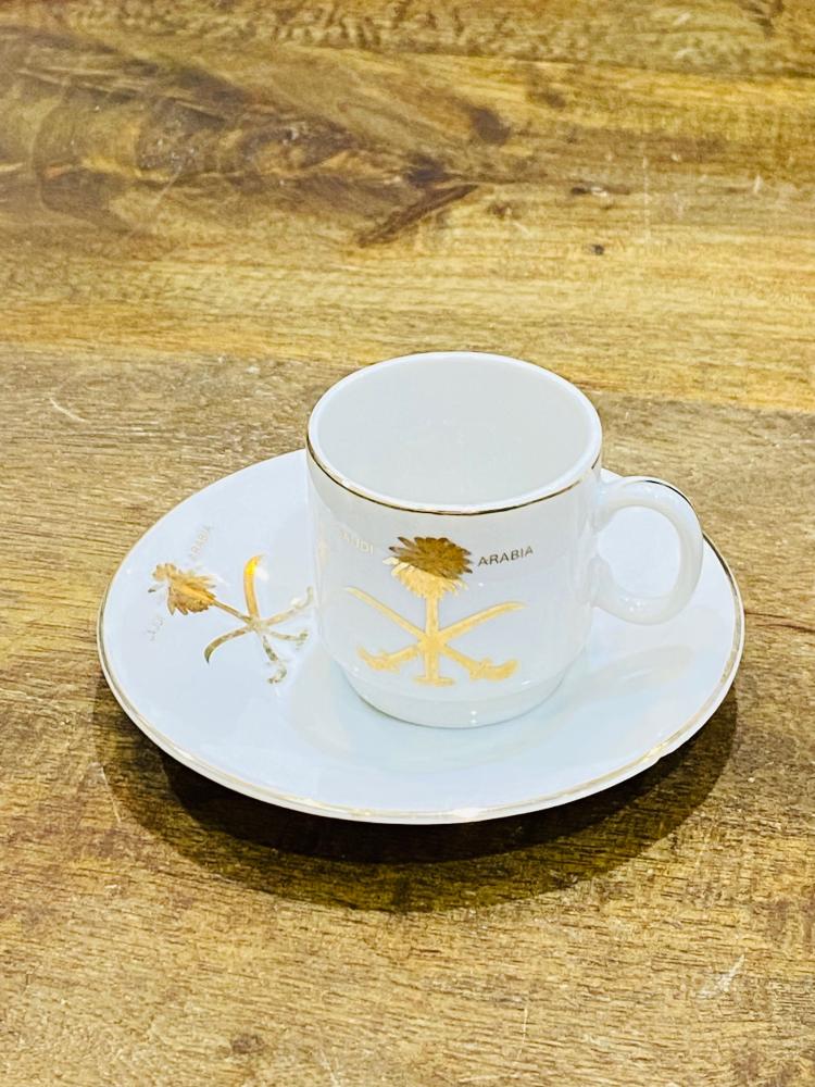 One of the very rare items; a 5 cm tall coffee cup made of pure porcelain with the country's emblem of two swords and a palm tree in gold color on the cup and saucer; expertly made, Japan craftsmanship (made specifically for one of the palaces) considered