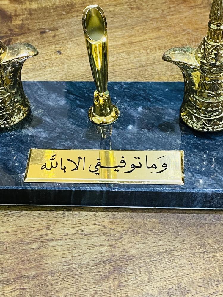 من القطع المميزة؛ تحفة جميلة عبارة عن قطعة رخام ثقيلة عليها دلتين من المعدن ومكان للقلم وقطعة معدنية مكتوب عليها (وما توفيقي إلا بالله) قديمة مخزنة تخزين ممتاز لم تستخدم