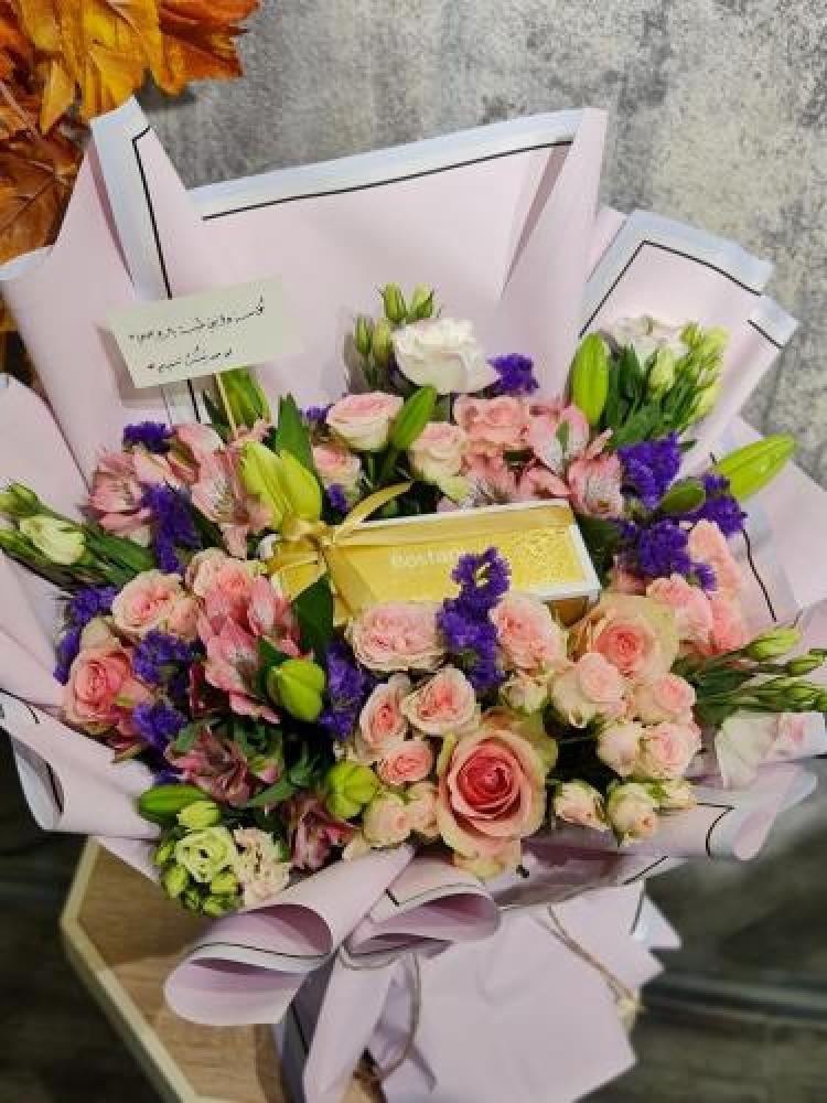 A bouquet of flowers with Bostani chocolates arranged with coordinated colored flowers