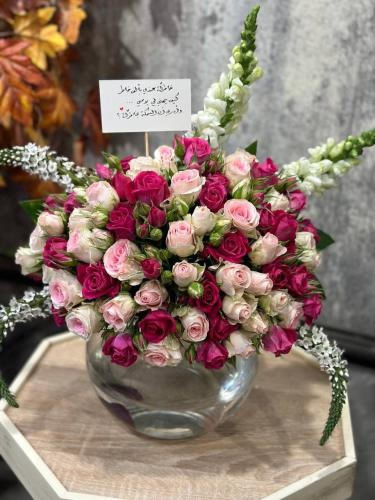 Vase of flowers with fish arranged with fuchsia and pink flowers