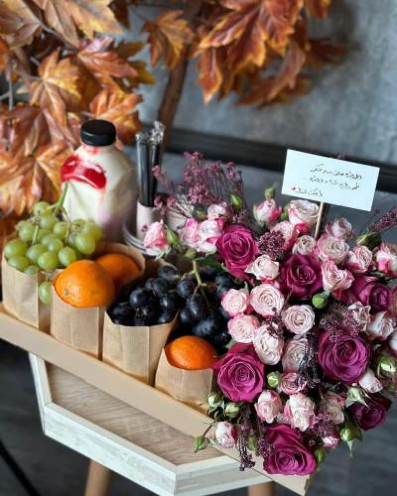 A gift of pink and white roses with myrrh, along with a luxurious juice jug and assorted fruits