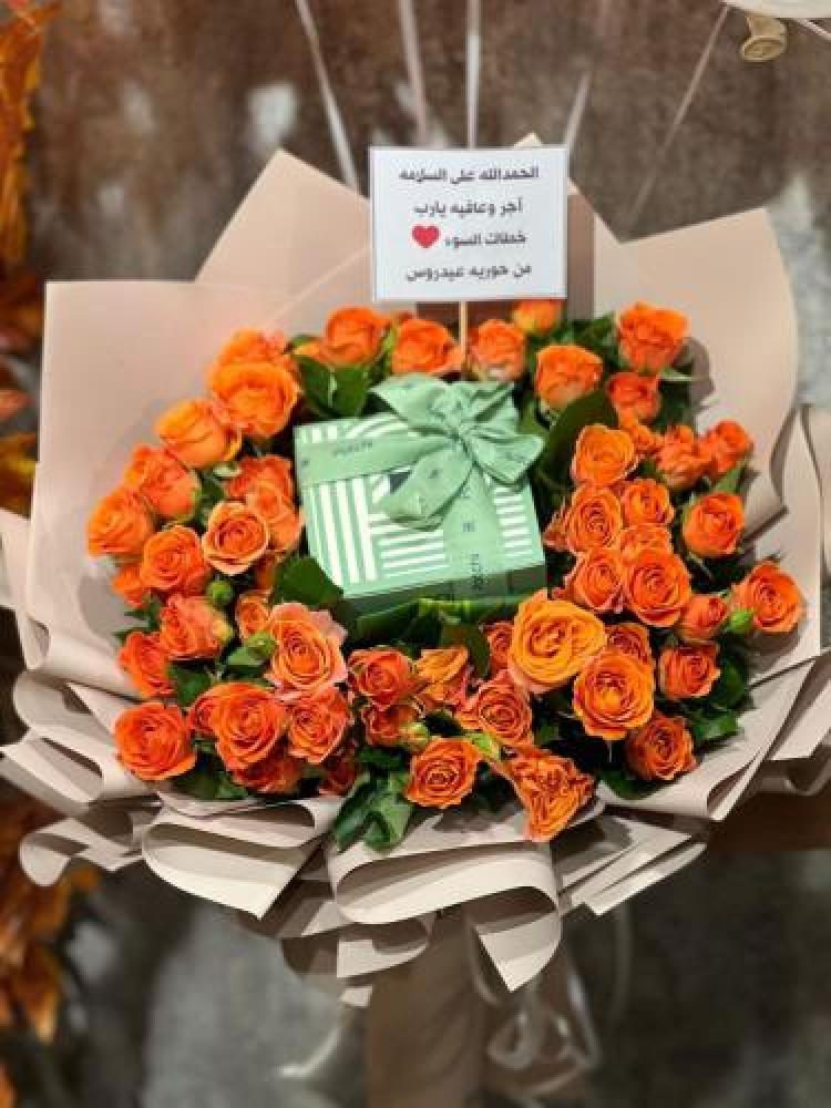 Pastry chocolate in the middle of a small bouquet of orange roses