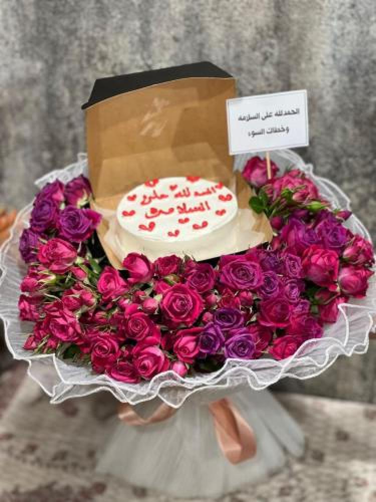 A bouquet of fuchsia and mauve baby pink roses with a cake stand