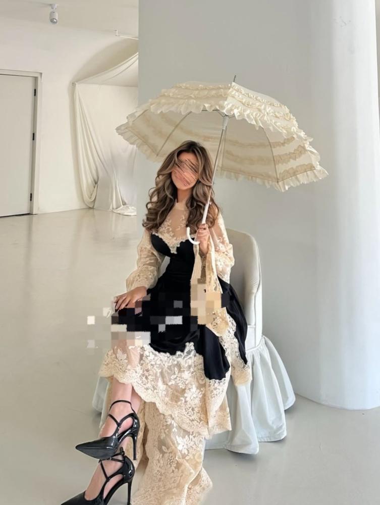 فستان أنيق باللون الأسود بتصميم راقٍ، مزين بتطريز دانتيل فاخر بلون عاجي عند الصدر والأكمام