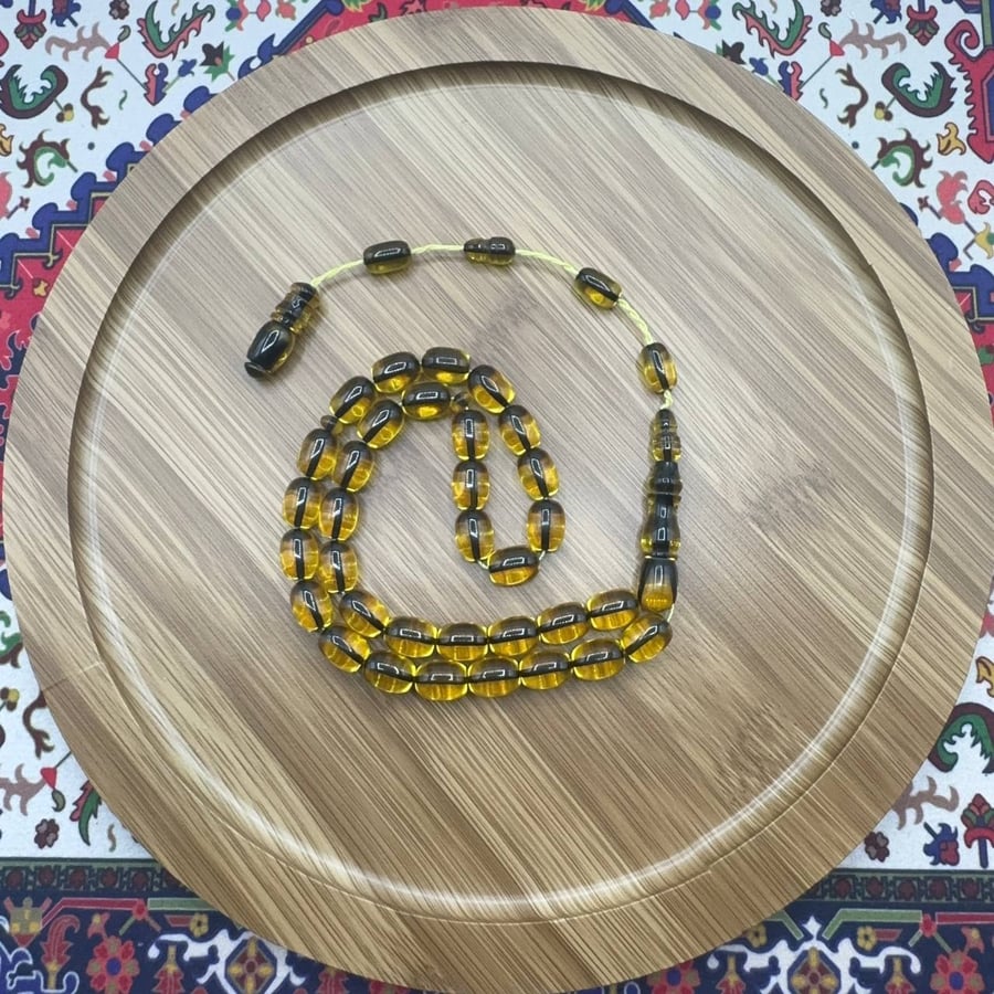 سبحة فاتوران أصفر ذهبي بلسمات سوداء خفيفة – 33 خرزة