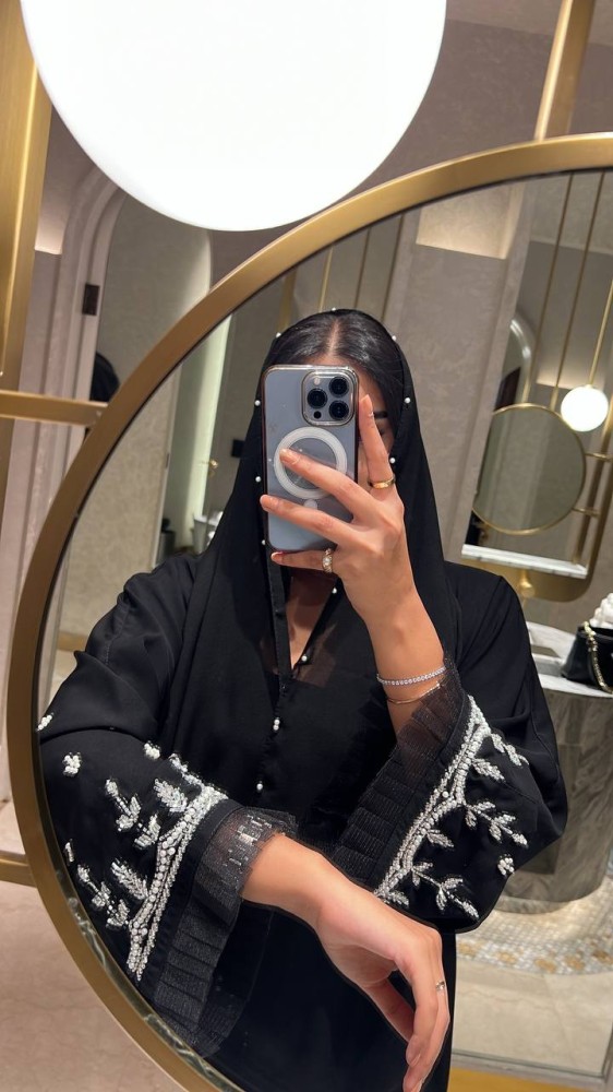 تفاصيل الشك اليدوي الأبيض على أكمام عباية سوداء
