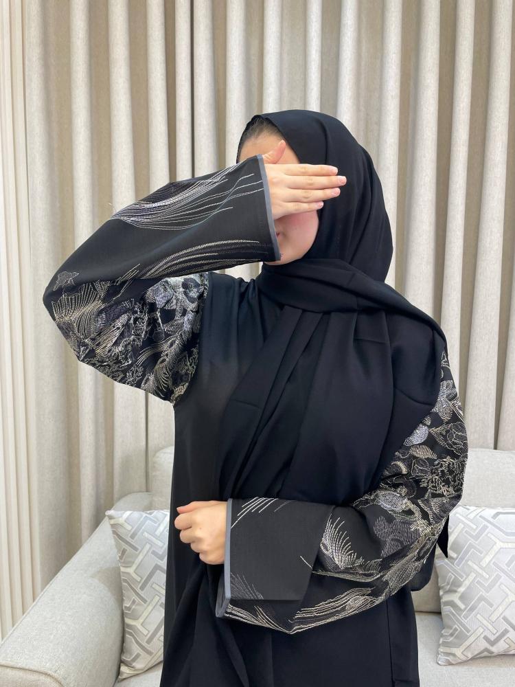 عباية اسود برسومات مستوحاة من الريش وسعف النخيل