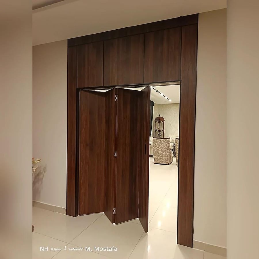 باب الطي مفتوحا وقد انطوت دفاته الخشبية الى جانب الفتحة