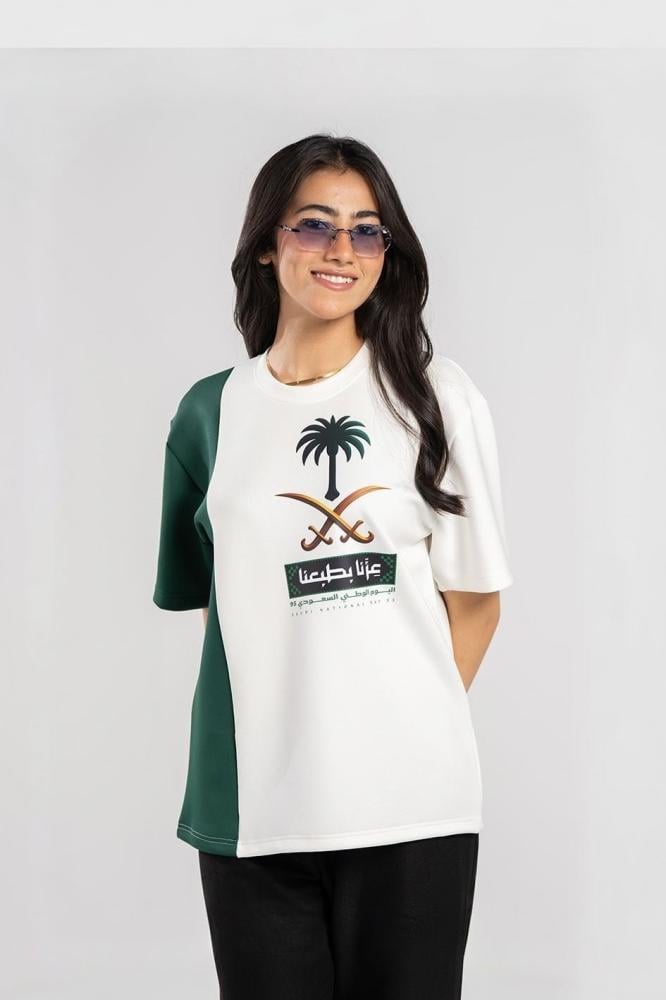 تيشيرت اليوم الوطني نصفين أخضر وأبيض طباعة عزّنا بطبعنا