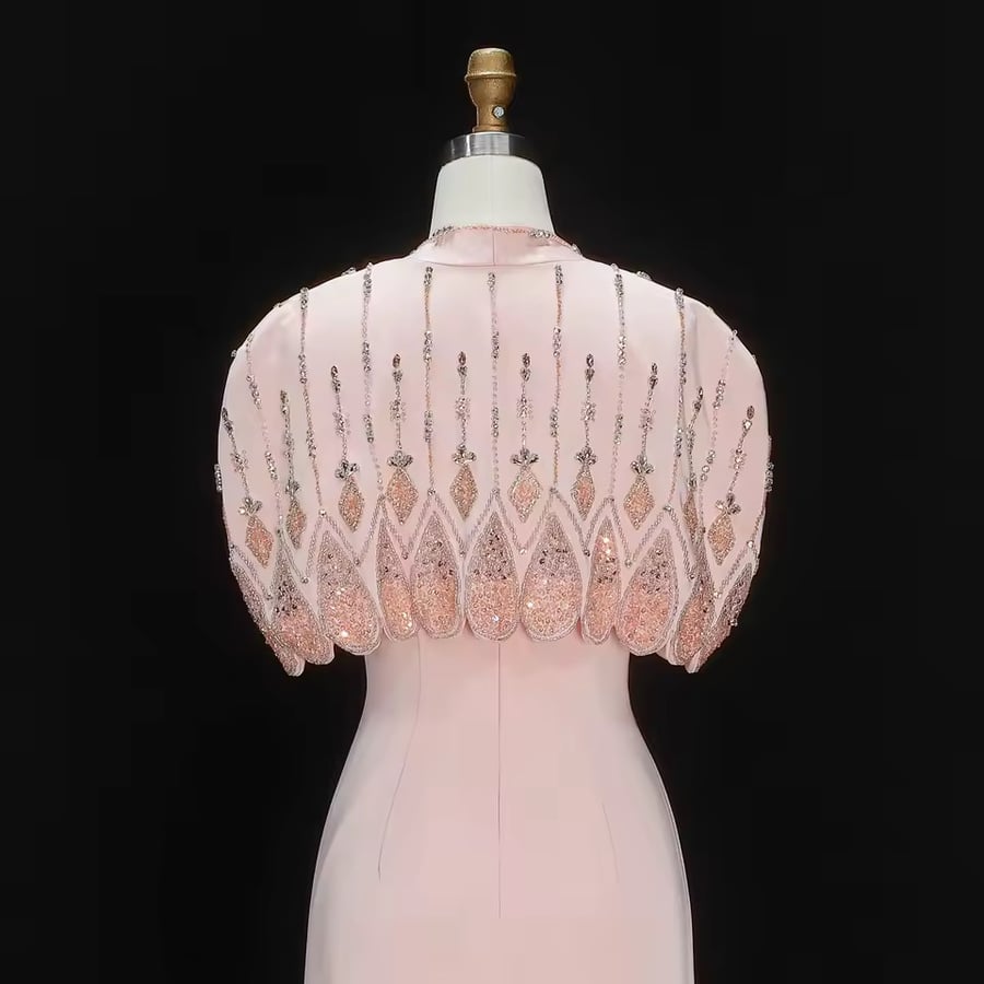 فستان سهره انيق باللون الوردي مع فتحه من الخلف بستره نظام كيب على الكتف مشغوله بالخرز والكريستال