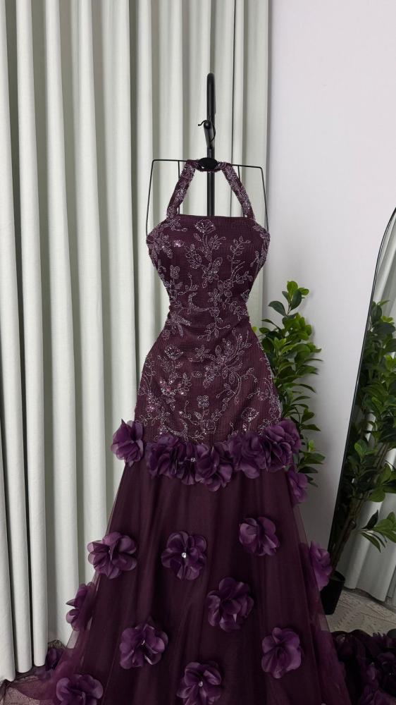 Dark purple dress with details at the waist and tulle with roses