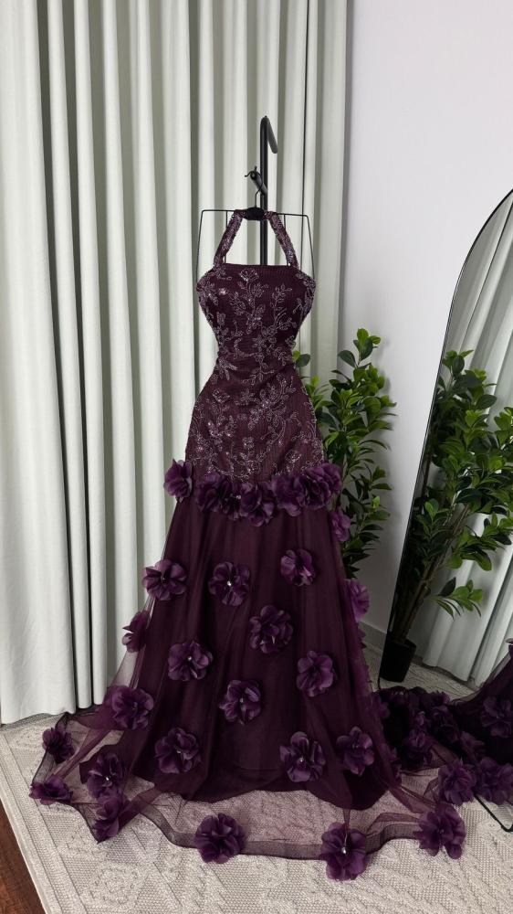 Dark purple dress with details at the waist and tulle with roses