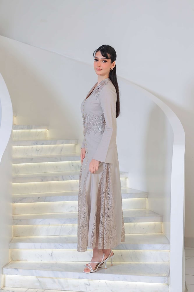 فستان طويل يجسد الأناقة الهادئة بلمسة فاخرة بتطريز ناعم وتفاصيل دانتيل أنثوية