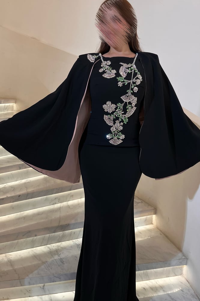 فستان سهرة أسود فاخر بتصميم ملكي يجمع بين الأناقة والهيبة.