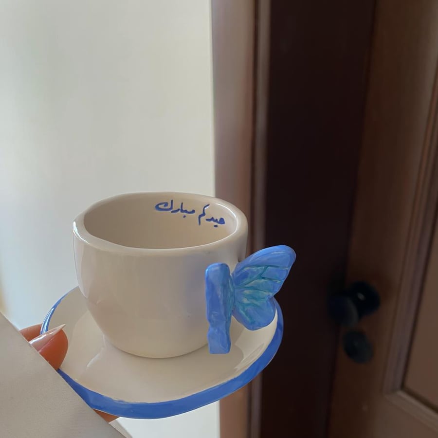 كوب اسبريسو وصحن بممسك فراشه