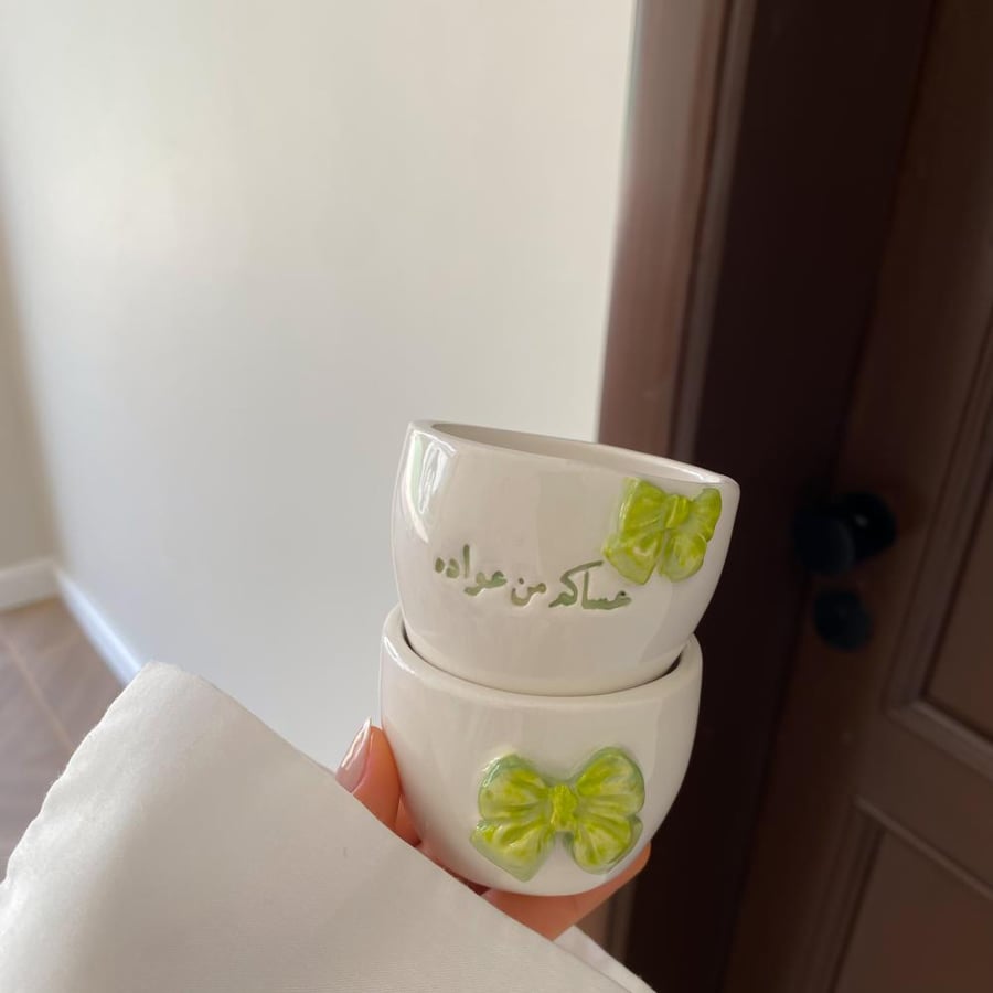 Two cups with a phrase and a bow