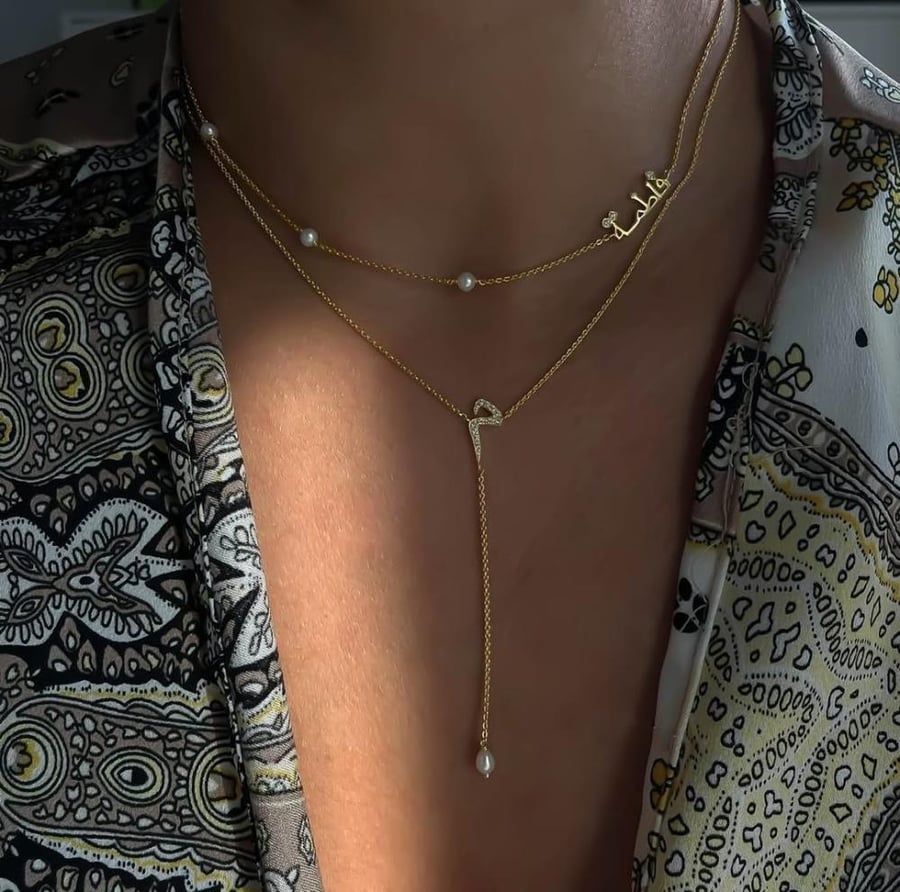 A necklace with the name and letter with zircon