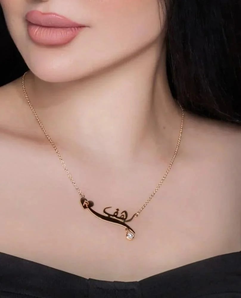 A necklace with the name and letter with a gemstone