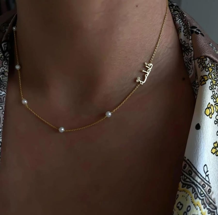 A necklace with the name and letter with zircon