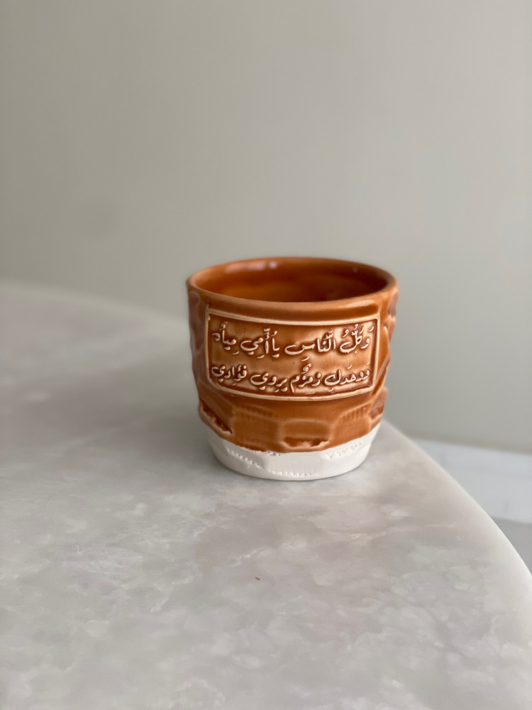 كوب بعبارة ( وَكلُّ النَّاسِ يا أُمِّي مِياهٌ ‏وَوحدَكِ زمزمٌ يروِي فؤادِي)