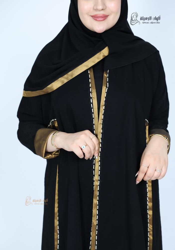 تفاصيل عباية سوداء بشريط ذهبي وغرز بيضاء على الصدر والأكمام