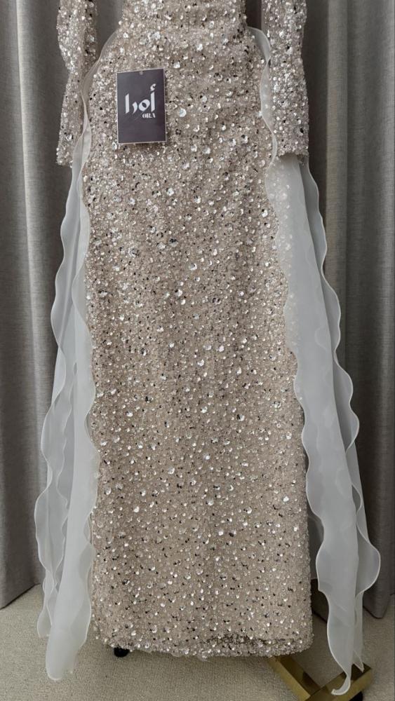 Beige evening dress with sequin embellishments and a pleated train.