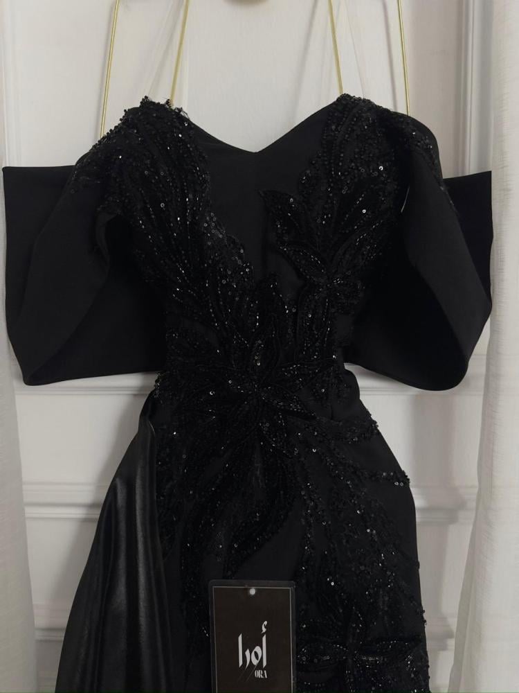 A black dress with elegant trim and a Barbie-style butcher's tail with a sheen.