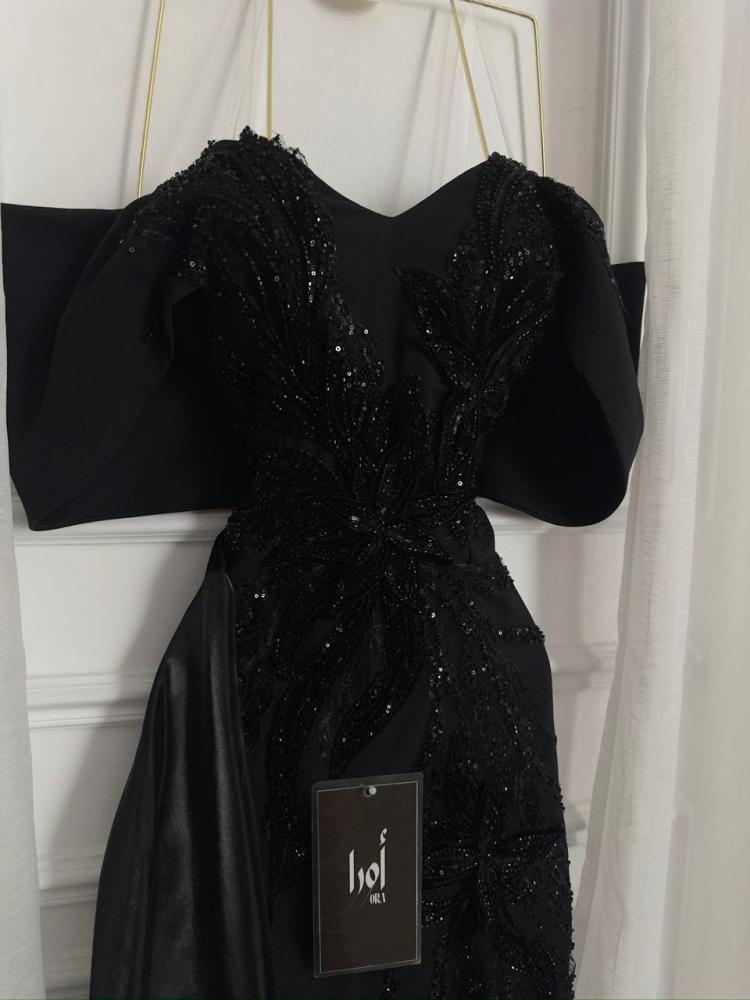 A black dress with elegant trim and a Barbie-style butcher's tail with a sheen.
