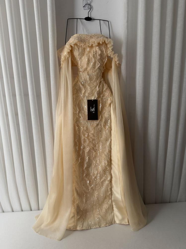 A gold dress with embroidered details, long crinkle sleeves