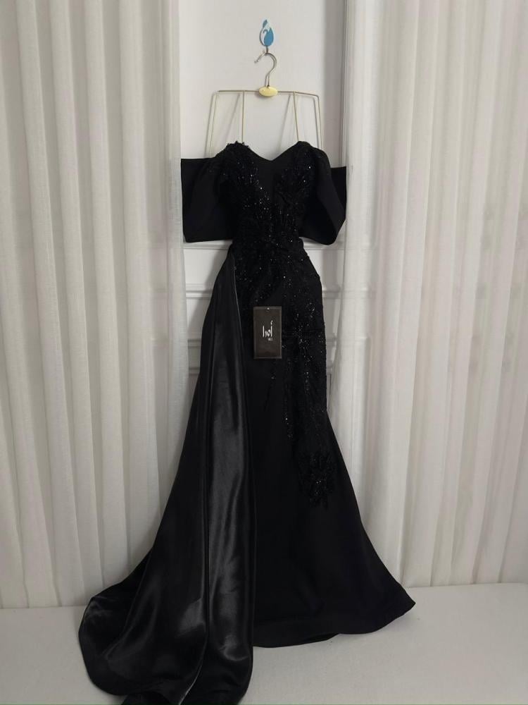 A black dress with elegant trim and a Barbie-style butcher's tail with a sheen.