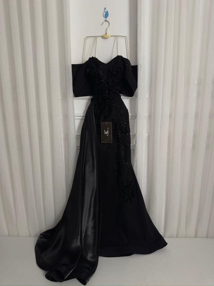 A black dress with elegant trim and a Barbie-style butcher's tail with a sheen.